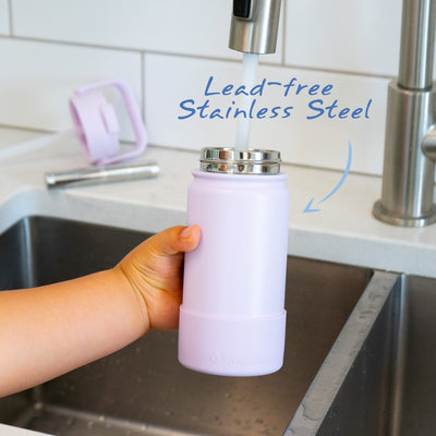 Bouteille Santevia Kids Lavender remplie à l'évier par un enfant avec le filtre de la bouteille d'eau Santevia à l'arrière-plan. Acier inoxydable sans plomb