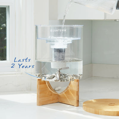 Système d'eau en verre Santevia dans une cuisine ensoleillée d'un blanc éclatant. Les pierres minérales Santevia ont une durée de vie de 2 ans.