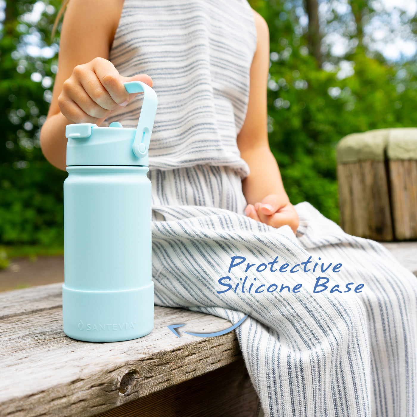 Santevia Kids Bottle Glacier being held by child sitting on wooden bench. Protective Silicone Base