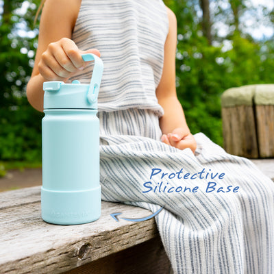 Santevia Kids Bottle Glacier being held by child sitting on wooden bench. Protective Silicone Base