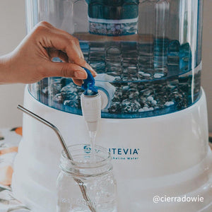 @cierradowie closeup of a Santevia Gravity Water System pouring into a mason jar with a metal straw